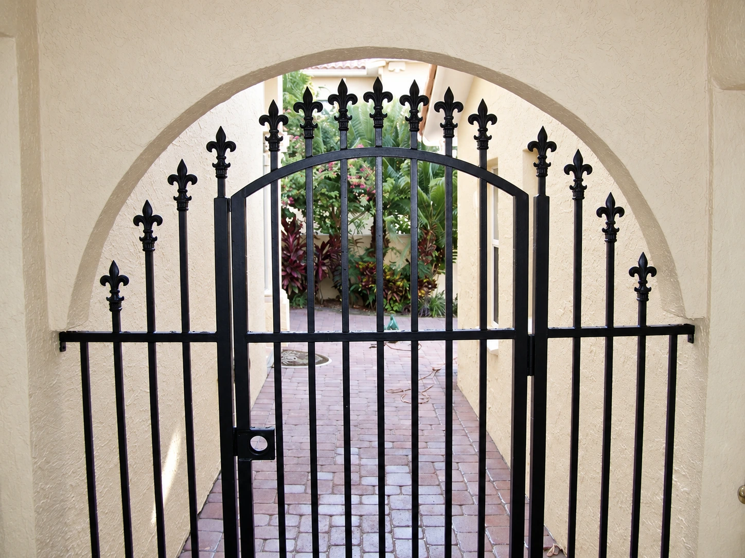 An arched metal gate with decorative finials, made by Al’s Mobile Welding